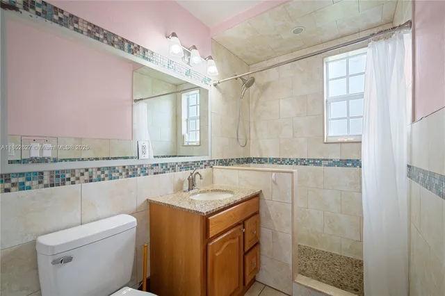 a bathroom with a granite countertop sink a mirror and a shower