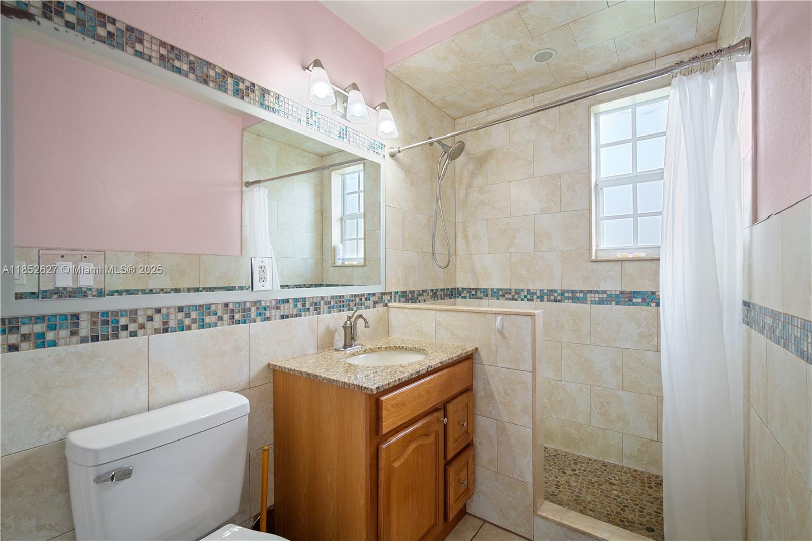 29001 Southwest 157th Avenue Homestead, FL 33033 - Photo 14 of 23 a bathroom with a granite countertop sink a mirror and a shower