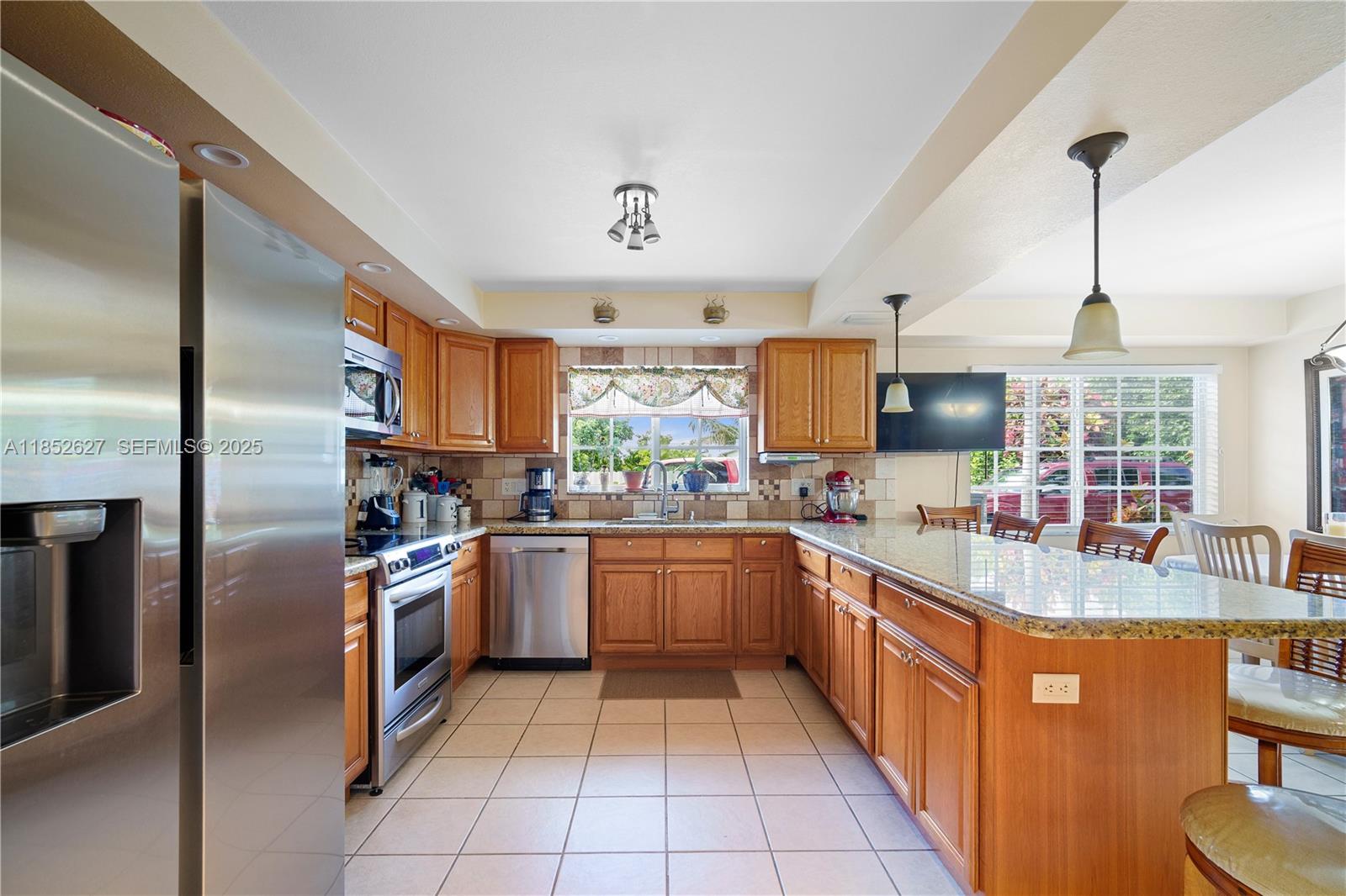 29001 Southwest 157th Avenue Homestead, FL 33033 - Photo 22 of 23 a kitchen with stainless steel appliances granite countertop a sink and a refrigerator