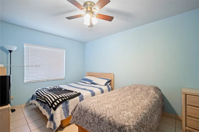 a bedroom with two beds and a chandelier