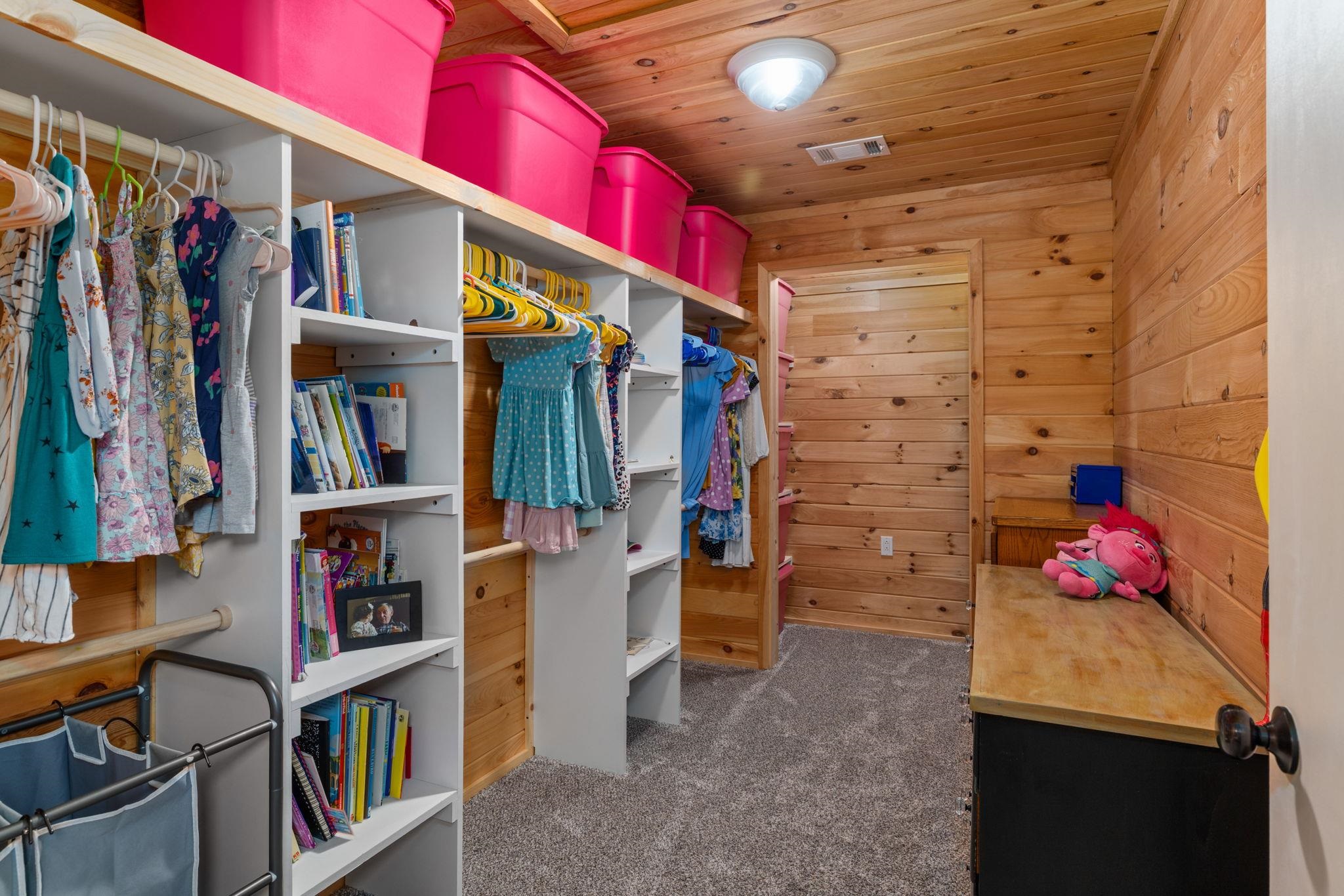 66 County Road 511 Corinth, MS 38834 - Photo 21 of 40 Custom closet featuring wood-paneled walls and ceiling, built-in shelving, hanging rods, and carpeted flooring