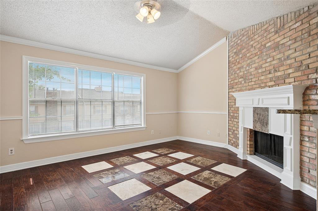 an empty room with windows and fireplace