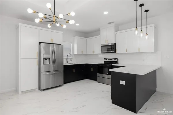 a kitchen with stainless steel appliances granite countertop a refrigerator a stove a sink and a refrigerator