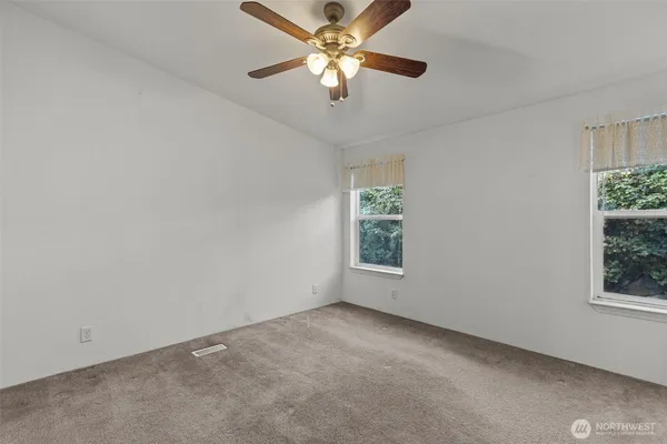 an empty room with a window and a fan