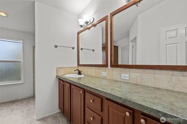 a bathroom with a granite countertop sink and a mirror