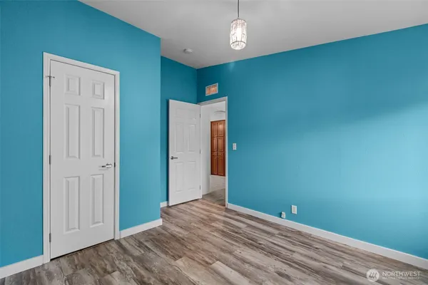 an empty room with wooden floor and closet