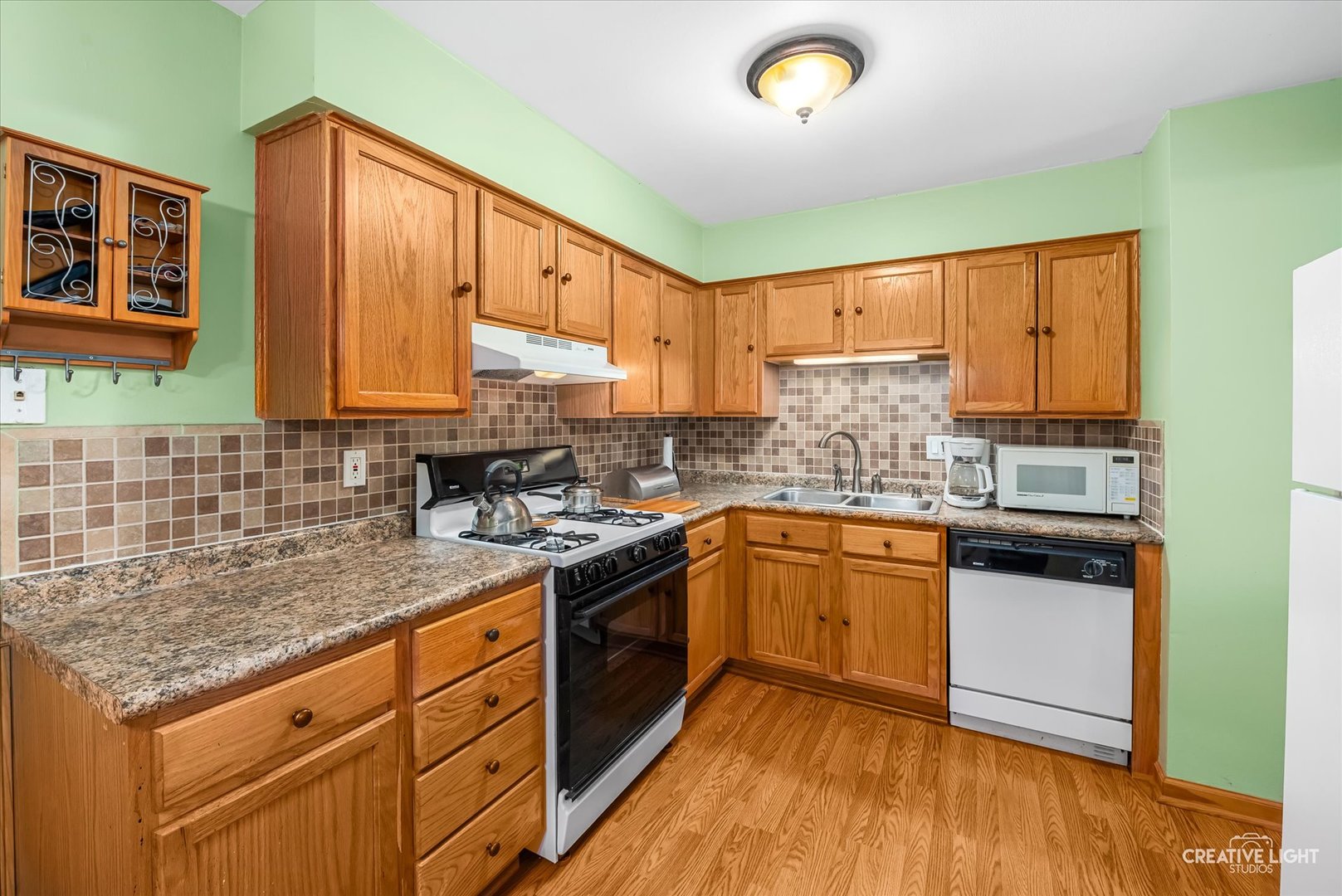 19360 Wolf Road, Unit 9 Mokena, IL 60448 - Photo 5 of 16 a kitchen with a sink a stove and cabinets