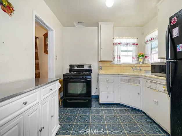 a kitchen with a stove and white cabinets