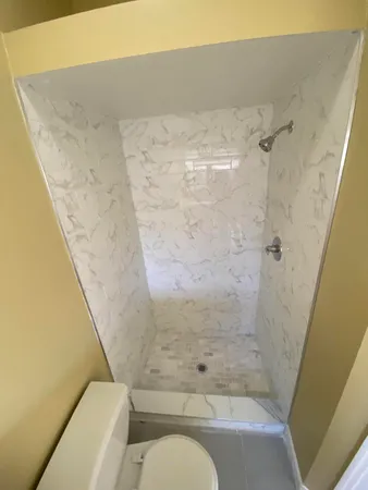 a bathroom with a toilet and shower