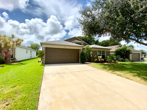 a front view of house with yard and car parked
