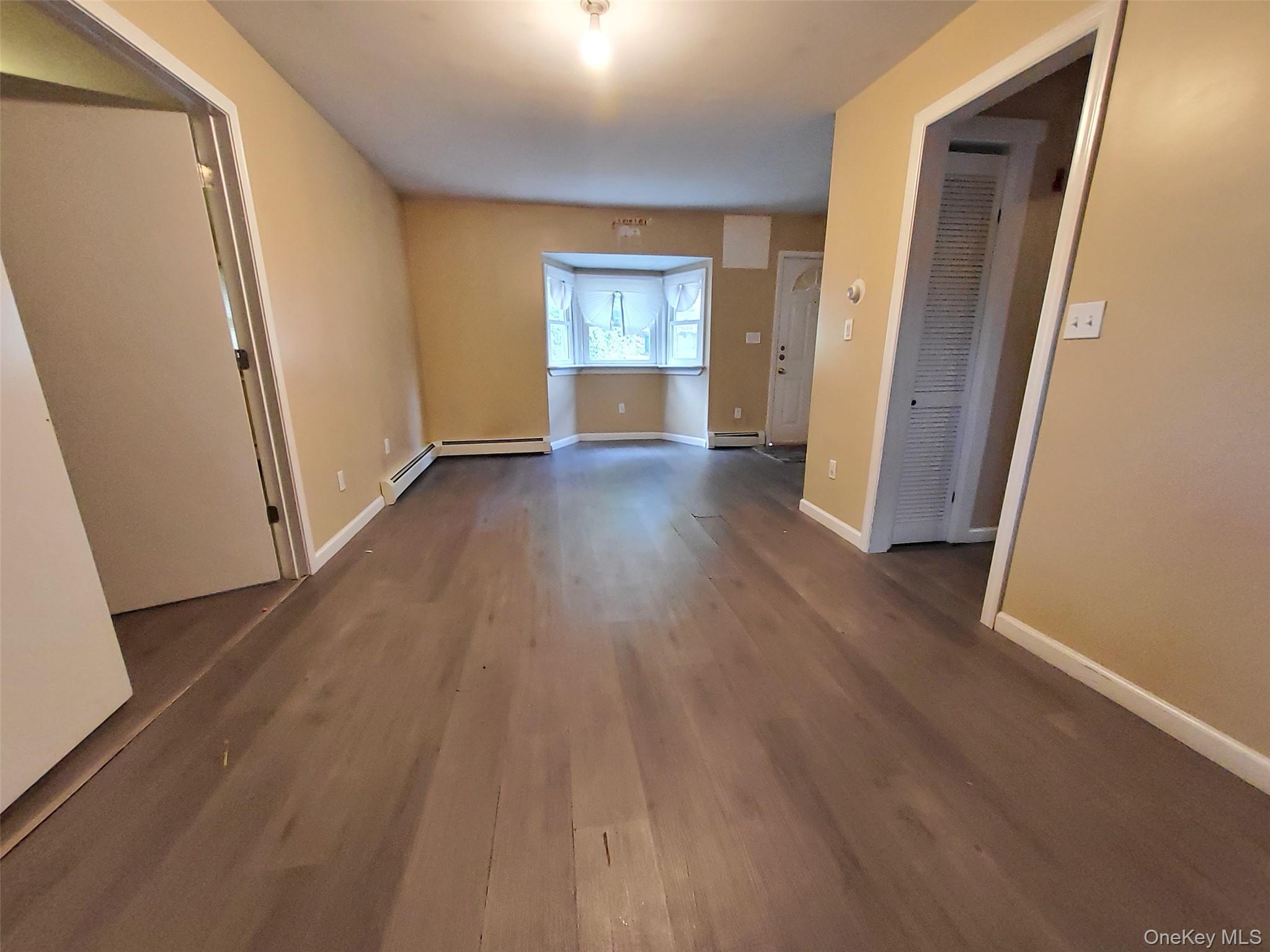 469 Hillside Road Monroe, NY 10950 - Photo 9 of 20 an empty room with wooden floor and windows