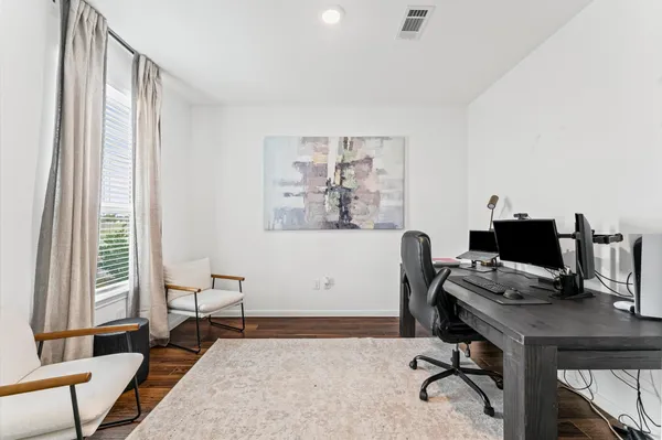 a view of a workspace with furniture and a window