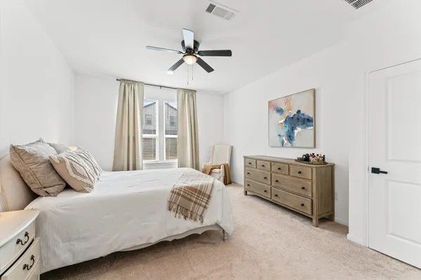 a bedroom with a bed dresser and wooden floor