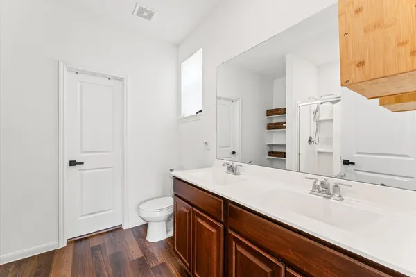 a bathroom with a sink a toilet and a large mirror