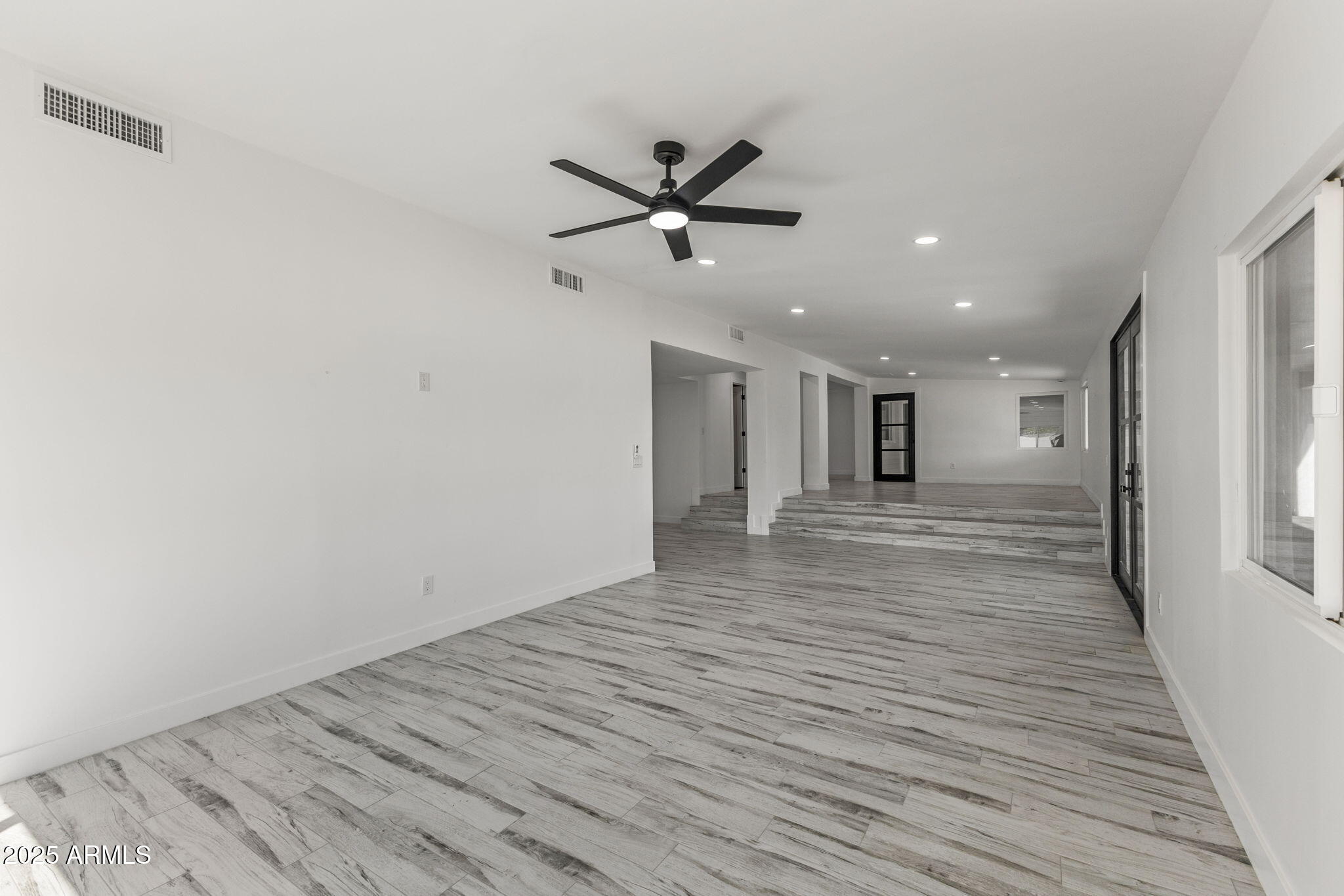 5219 East Lone Mountain Road Cave Creek, AZ 85331 - Photo 25 of 88 a view of an empty room with wooden floor and a ceiling fan