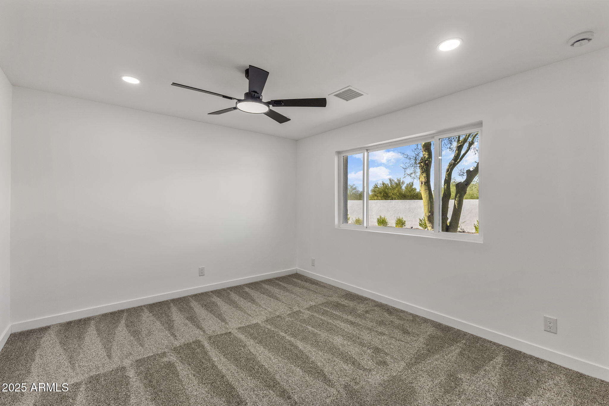 5219 East Lone Mountain Road Cave Creek, AZ 85331 - Photo 43 of 88 an empty room with windows and ceiling fan