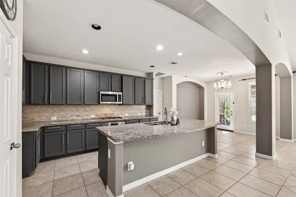 a kitchen with kitchen island granite countertop a sink and cabinets