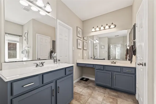 a spacious bathroom with a sink double vanity granite and a mirror