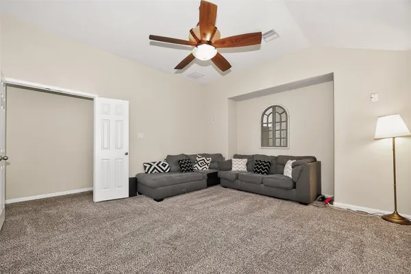 a living room with furniture and a ceiling fan