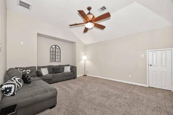 a living room with furniture and a ceiling fan