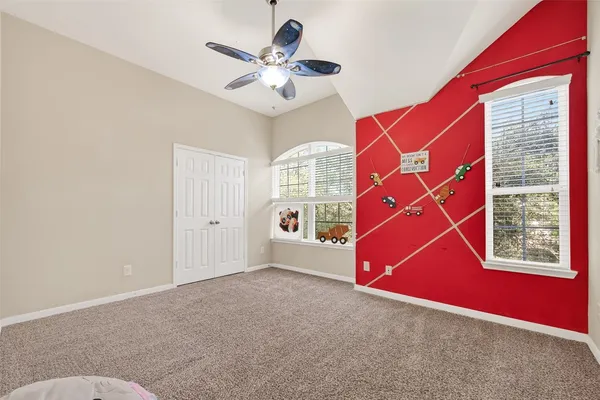 an empty room with windows and fan