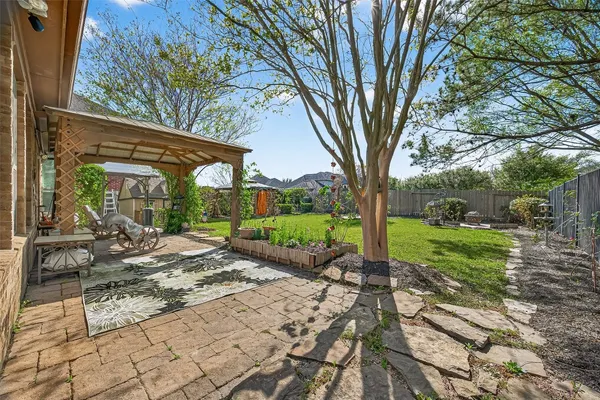 a view of a patio with table and chairs under an umbrella