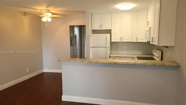 a kitchen with kitchen island a sink appliances and cabinets