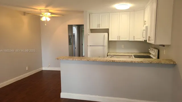 a kitchen with kitchen island a sink appliances and cabinets