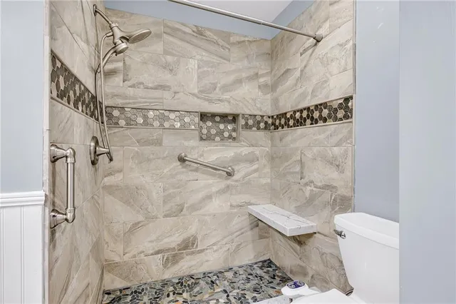 a bathroom with a toilet and a shower