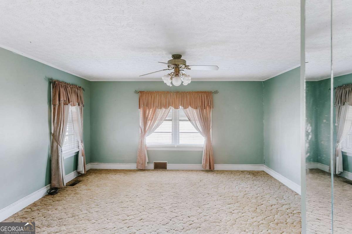 119 Ralph Bridges Road Lexington, GA 30648 - Photo 26 of 65 an empty room with windows and chandelier fan