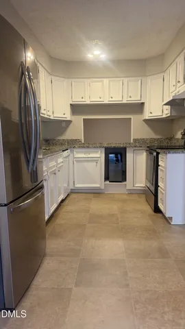 a kitchen with stainless steel appliances granite countertop a refrigerator a sink a stove and oven with wooden floor