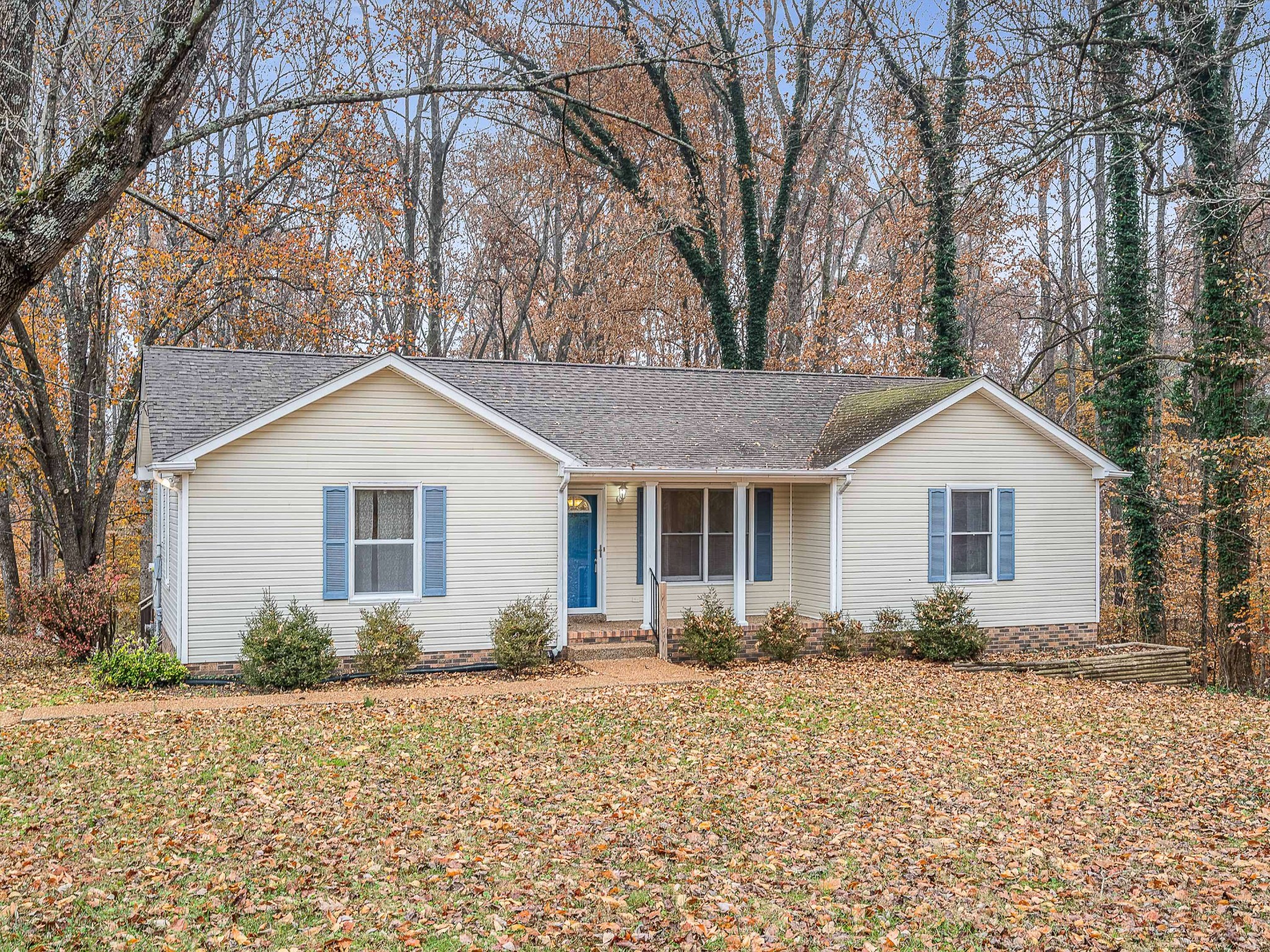 a front view of house with yard and trees around