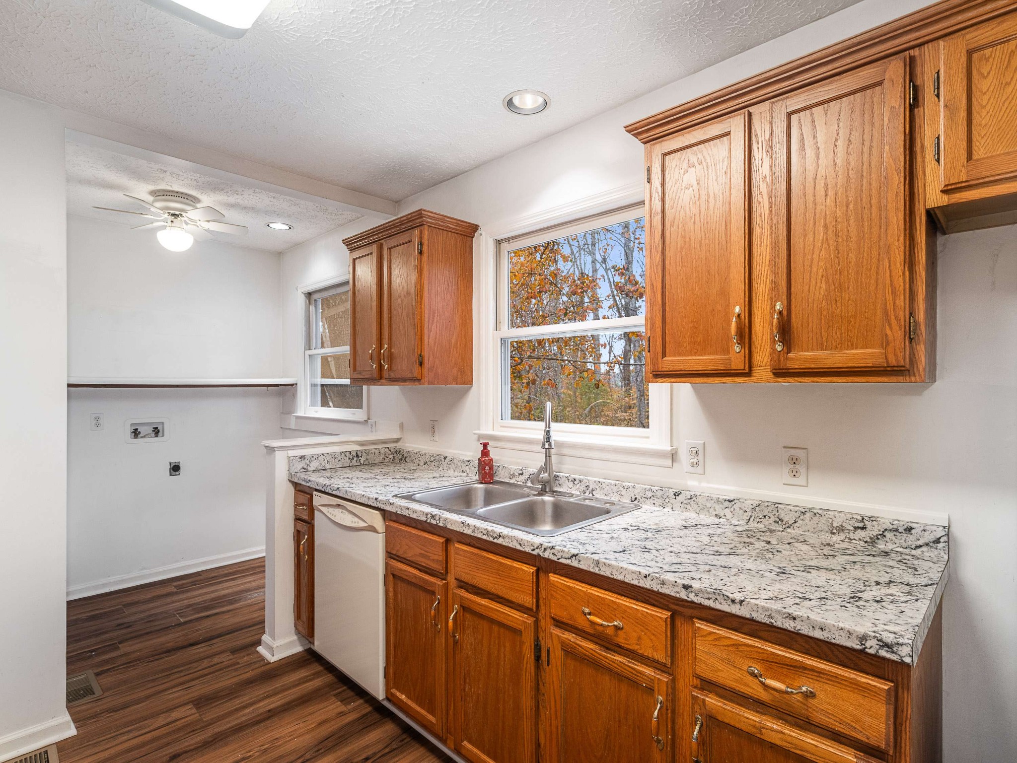 7125 Sutton Place Fairview, TN 37062 - Photo 15 of 36 a kitchen with stainless steel appliances granite countertop wooden cabinets a sink and dishwasher with wooden floor