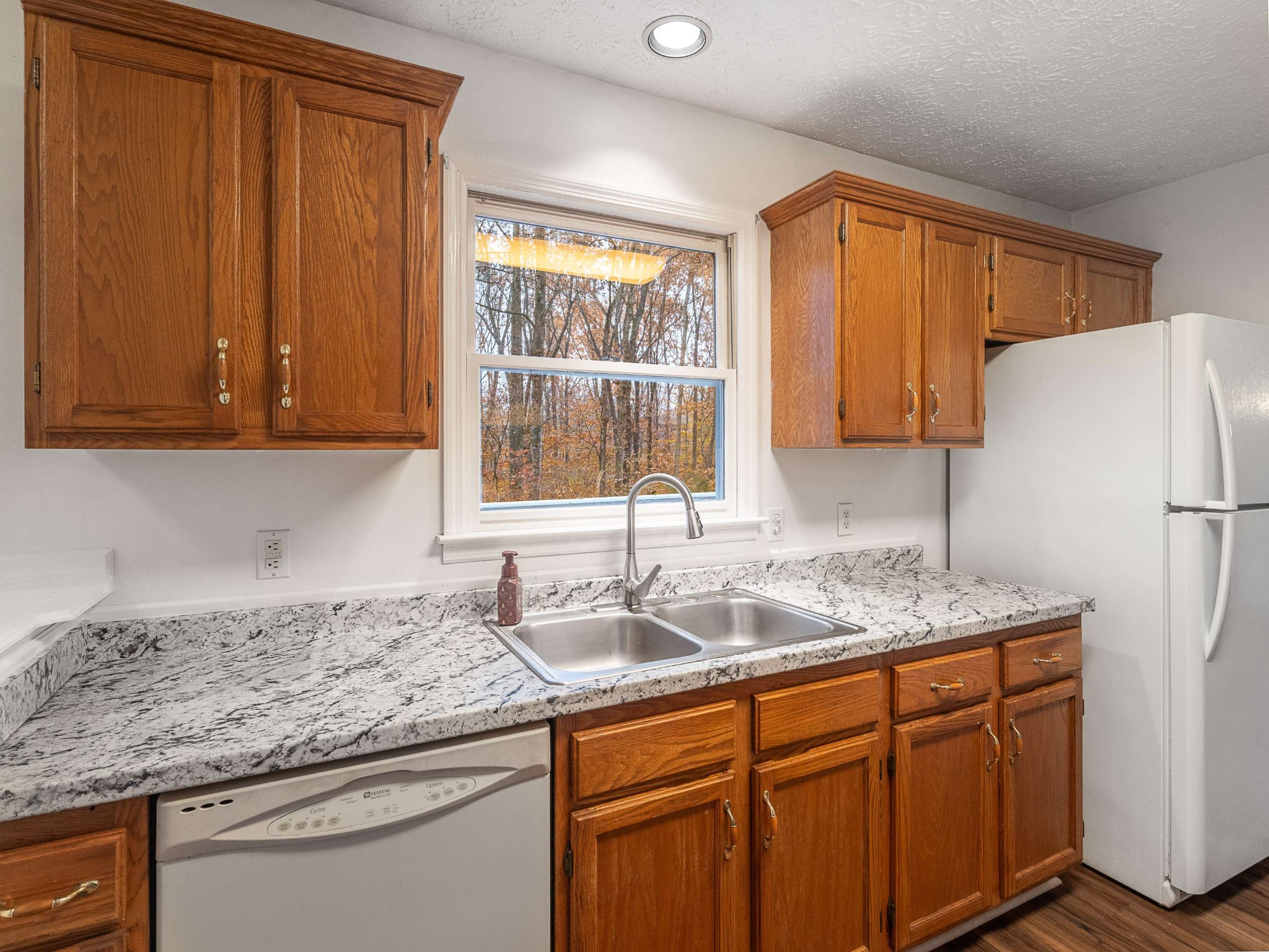 7125 Sutton Place Fairview, TN 37062 - Photo 19 of 36 a kitchen with granite countertop cabinets sink and window