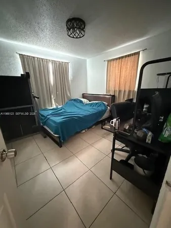 a living room with a bed furniture and a flat screen tv