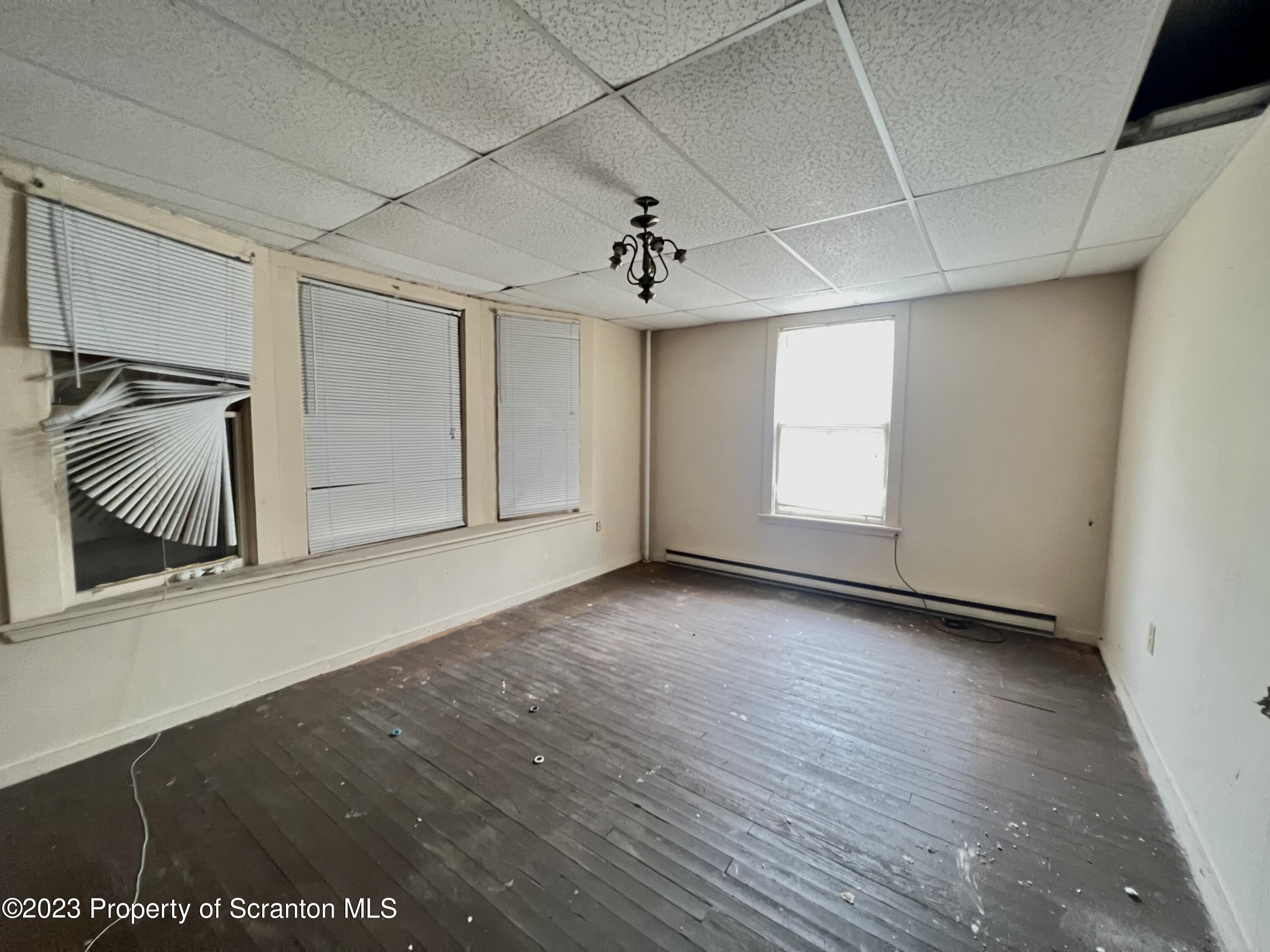 352-354 Maple Street Scranton, PA 18505 - Photo 7 of 22 an empty room with wooden floor and windows