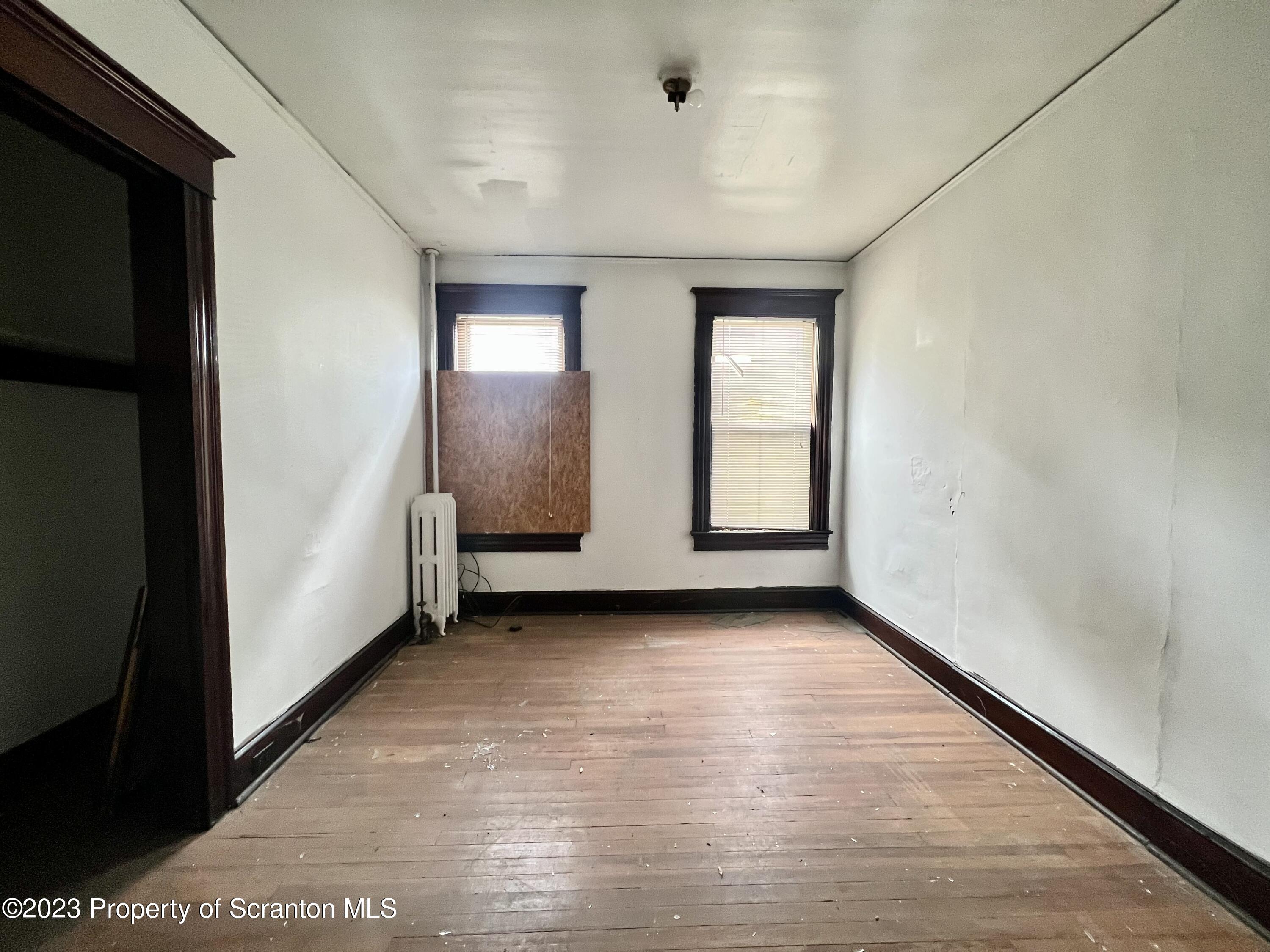 352-354 Maple Street Scranton, PA 18505 - Photo 8 of 22 an empty room with wooden floor and windows