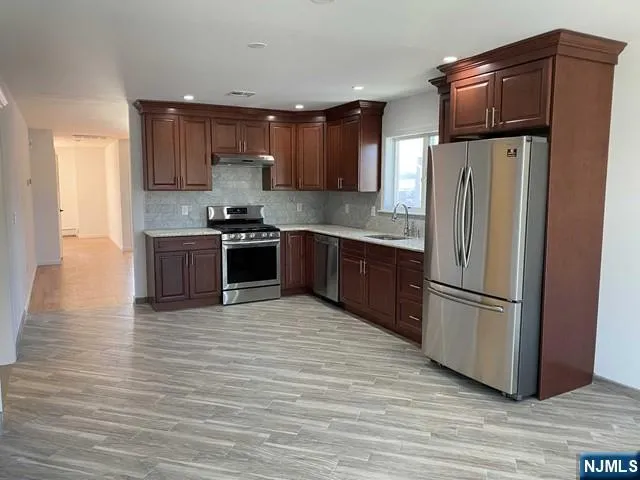 a kitchen with stainless steel appliances granite countertop a refrigerator and a stove