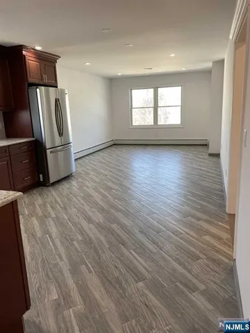 a view of a refrigerator in kitchen and wooden floor