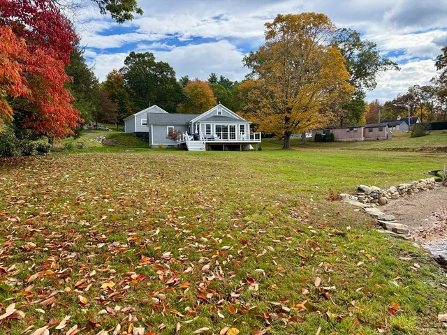 a front view of a house with a garden and trees