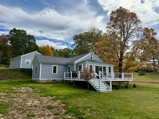 a view of house with swimming pool and a yard