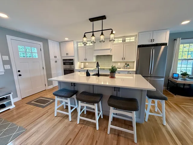a dining room with stainless steel appliances kitchen island granite countertop a dining table chairs and granite counter tops