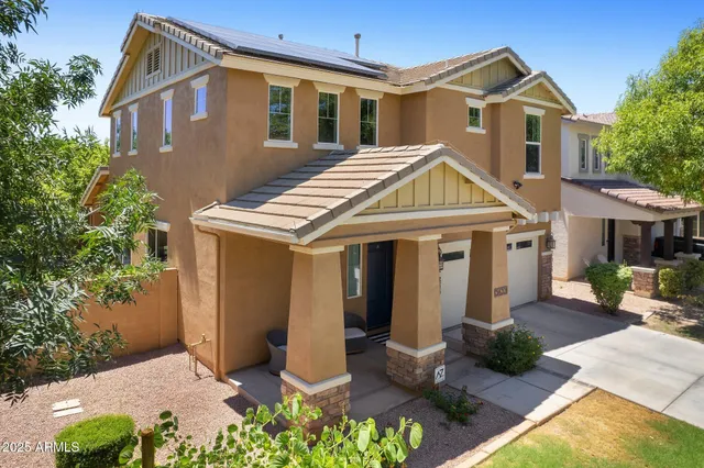 a view of a house with a yard and potted plants