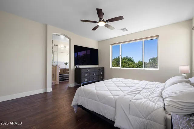 a bedroom with a bed window and a flat screen tv