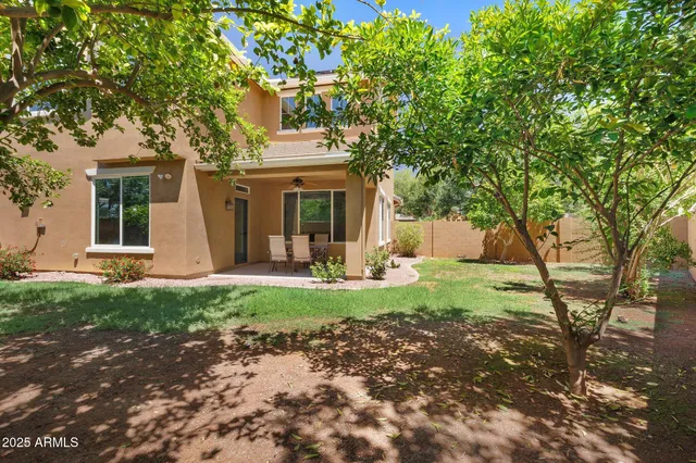 a view of a house with backyard and a tree