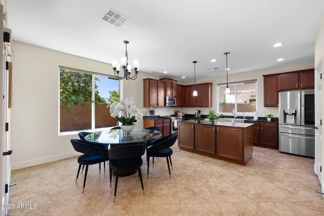 a kitchen with a refrigerator a stove a sink dishwasher with a dining table and chairs