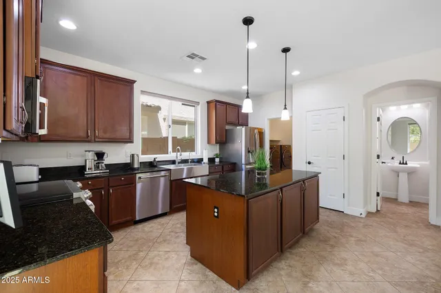 a kitchen with stainless steel appliances granite countertop sink stove and refrigerator