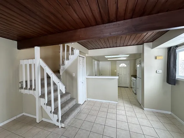 a kitchen with a refrigerator and white cabinets