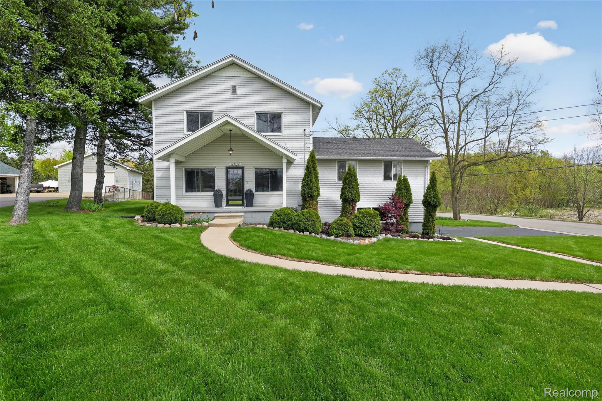 12409 Fenton Road Fenton, MI 48430 - Photo 58 of 61 View of front of property featuring a front lawn and covered porch
