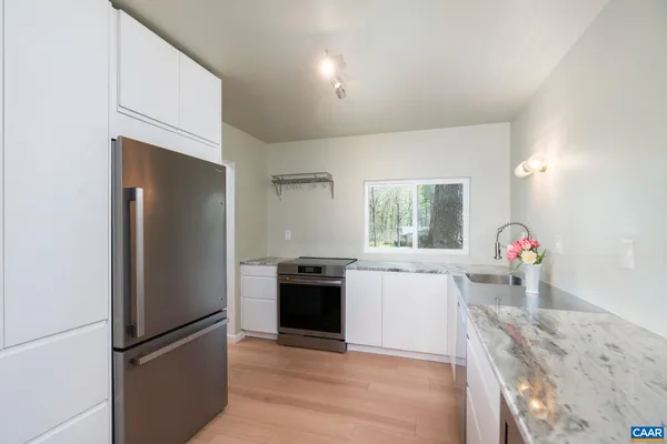 a kitchen with granite countertop a refrigerator and a sink